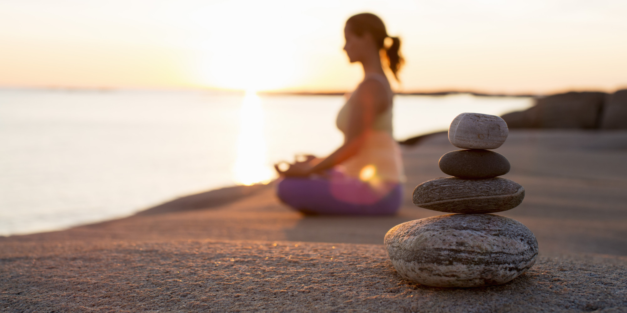 woman practices meditation on beach
