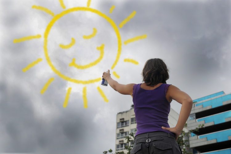 woman draw sunshine in sky focused on positive thinking